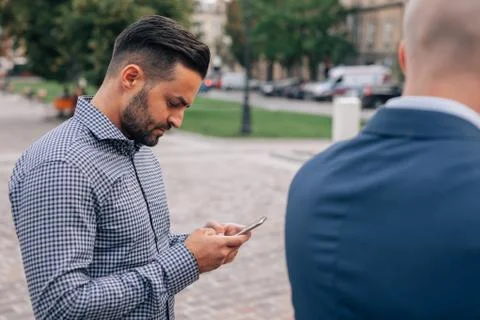 Two elegant men standing with mobile phone. Stock-Fotos
