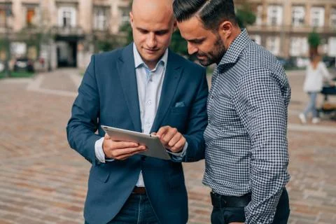 Two elegant men standing with tablet pc. Stock Photos