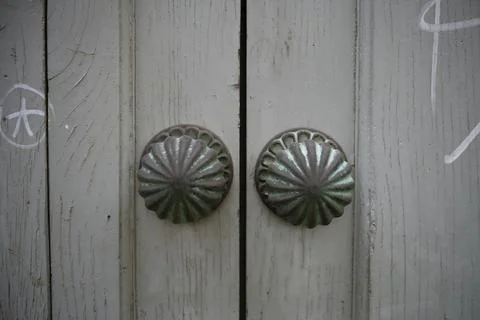 Two elegant round door knobs adorning a weathered wooden door Fotos de archivo