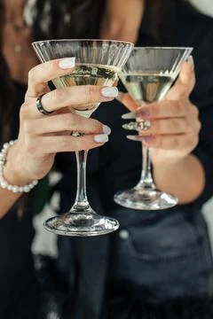 Two elegantly dressed individuals hold sparkling drinks, raising their glasse Fotos Stock