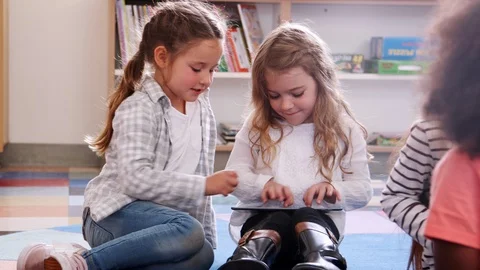 Two elementary school schoolgirls sharing tablet in class 動画素材 95965318