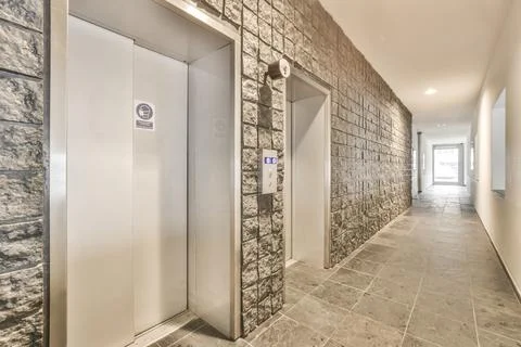 Two elevators in a hallway with a tile floor Stockfoto's