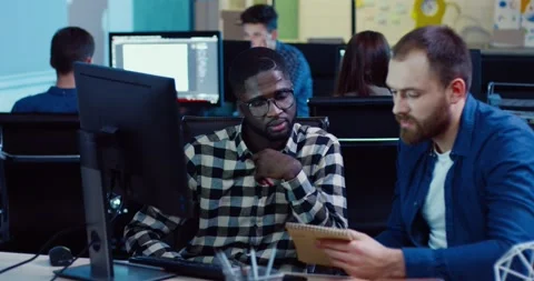 Two employees are sitting at computer looking for solution to problem. Young Stock Footage 140289506