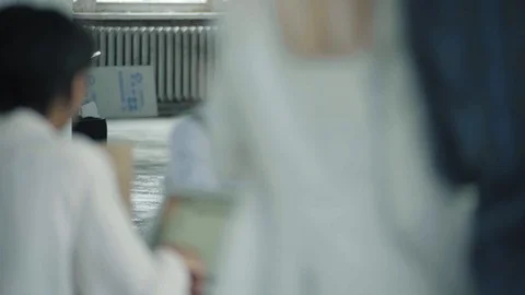 Two employees are sitting at a table with a laptop, working and chatting with Stock Footage 124328093