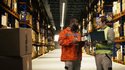 Two employees checking parcel status on package tracking interface Stock Photos