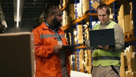 Two employees checking parcel status on package tracking interface Stock Photos