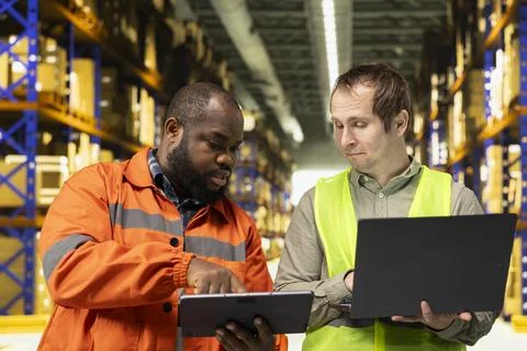 Two employees checking parcel status on package tracking interface Stock Photos