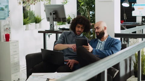 Two employees comparing notes in office Stock Footage 246393004
