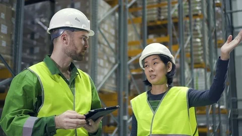Two employees discussing work with tablet computer at logistics warehouse Stock Footage 123226345