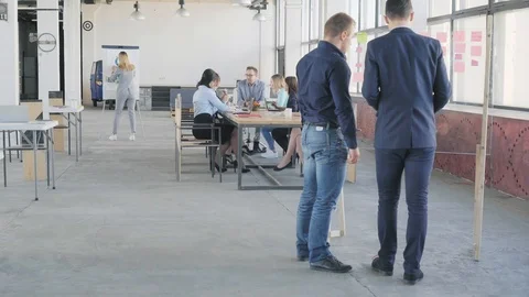 Two employees prepare preedntation on a glass board. In the background holds a Stock Footage 109378581