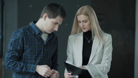 Two employees walk in a creative office business space and communicate Stock Footage 124327610