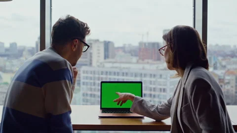 Two employees working chroma key device pointing screen in glass walls office Stock Footage 335246122