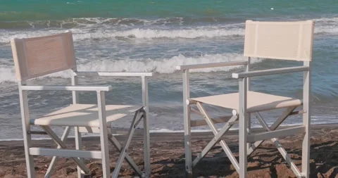 Two empty beach chairs in front of the beach with the rough sea Vídeo Stock 172446909