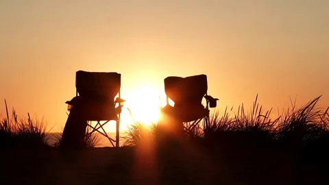 Two Empty Beach Chairs At Sunset Stock Footage