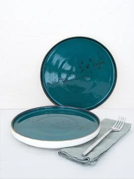 Two empty blue dinner plates with tablecloth on table with white background Stock Photos