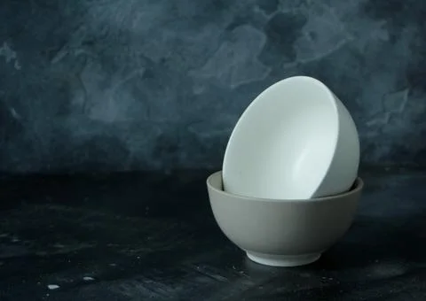 Two empty bowls in dark background Stock Photos