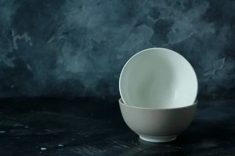 Two empty bowls in dark background Stock Photos