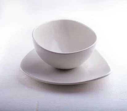 Two Empty bowls placed on a white surface Stock Photos