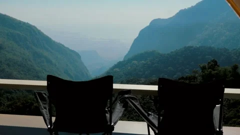 Two empty camping chairs near textile camping tent with mountain view. Place for 库存影片 219468109