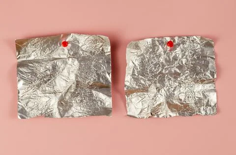 Two Empty candy wrappers pinned to a pink background. Rectangular pieces of c Stock Photos