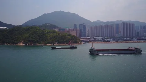 Two empty cargo ships sail along Hong Kong channel, aerial tracking shot Stock Footage 76938852