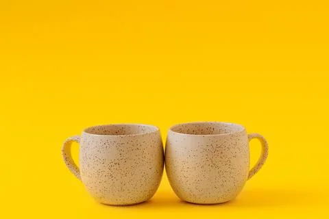 Two empty ceramic cups on a yellow background, copy space Stock Photos
