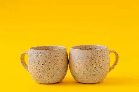 Two empty ceramic cups on a yellow background, copy space Stock Photos