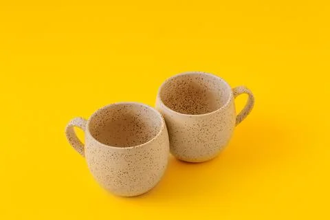Two empty ceramic cups on a yellow background, copy space Foto stock
