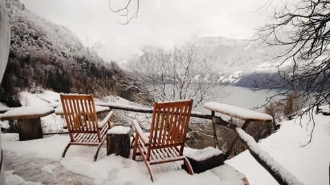Two empty chairs covered with a snow against beautiful background view of Swiss Stock Footage 259210773