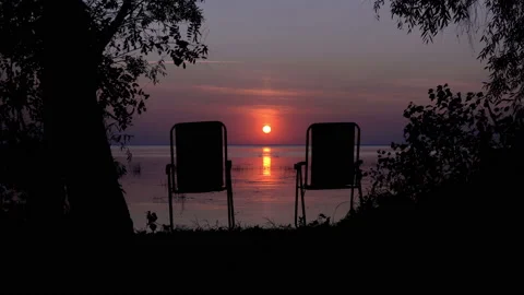Two empty chairs near the river at sunset Stock Footage 144789159
