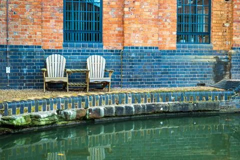 Two empty chairs next to canal river in england uk Stock Photos