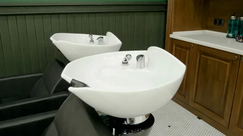 Two empty chairs with a wash basin at barbershop. 4K Stock Footage 92014218
