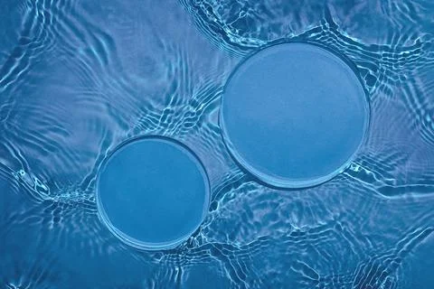 Two empty circle podiums on transparent dark blue water background Stock Photos