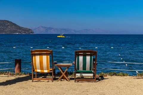 Two empty deck chairs on the shores of the Aegean Sea, relaxing in Turgutre.. Фото