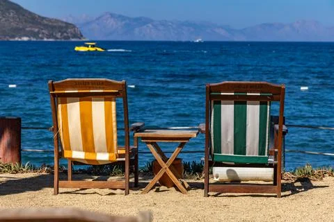 Two empty deck chairs on the shores of the Aegean Sea, relaxing in Turgutre.. Фото
