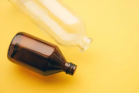 Two empty glass bottle of cosmetic liquid on light background Stock Photos