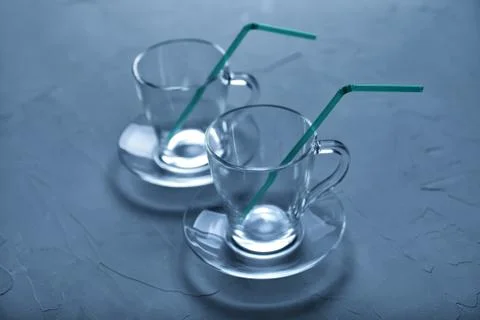 Two empty glass cups stand on a concrete background, toned blue color, soft f Foto stock