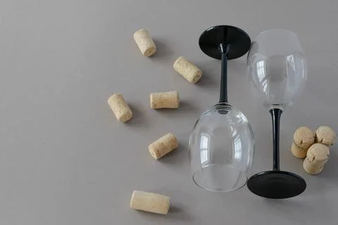 Two empty glass goblets with wine corks on a gray background. Stock Photos