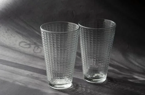 Two Empty Glasses on a gray surface with shadows. Stock Photos