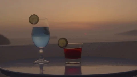 Two empty glasses standing on wooden table on background sea landscape from Stock Footage 105391783