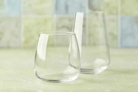 Two empty glasses for water or cocktails on light table. Glasses cup for drinks Stock Photos