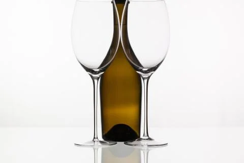 Two empty glasses of wine and brown bottle 库存照片