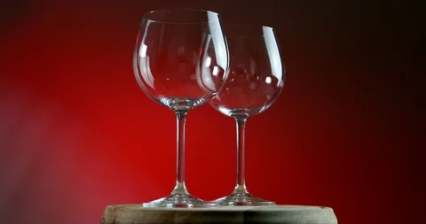 Two empty glasses for wine on a red background rotates on wooden platform Stock-Footage 91630478