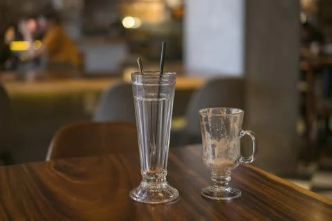 Two empty iced coffee glass cups on the table in coffee shop. Stock Photos