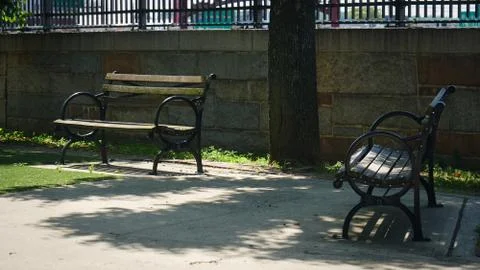 Two empty park benches on a sunny day during covid -19 pandemic Stock Photos