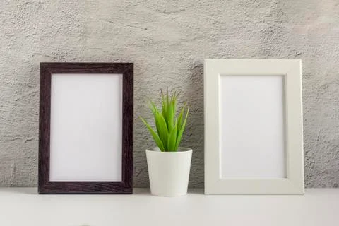 Two empty photo frames on a table or shelf with a copy of the space Stock Photos