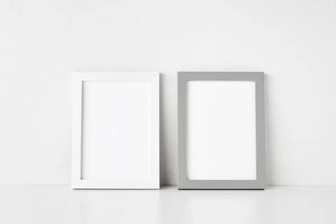 Two empty picture frames are placed on the white table by the wall. Copy space Foto stock