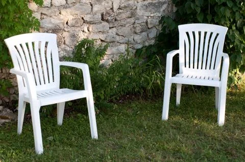 Two empty plastic chairs in the garden Foto stock