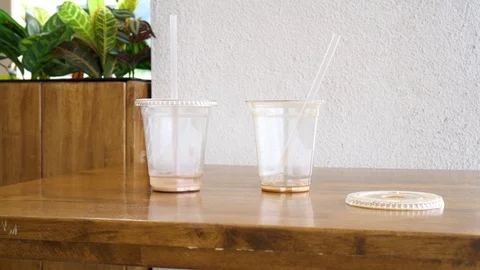 Two empty plastic coffee cups with straws on a table Stock Footage 91123061