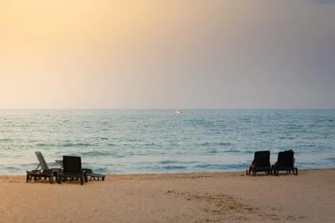 Two empty plastic sunbeds facing the sunset Stock Photos